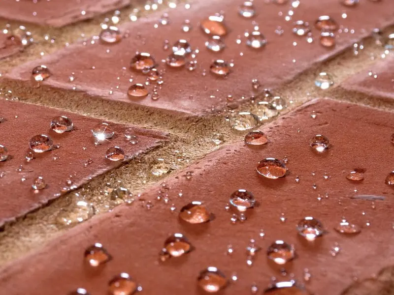 Rain beading into droplets at the face of a sound, well-pointed wall