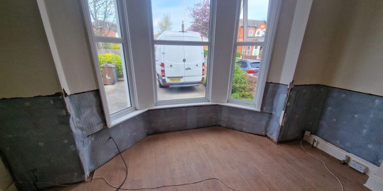 Damp proofing membrane fixed to the lower walls of a bay window room mid job